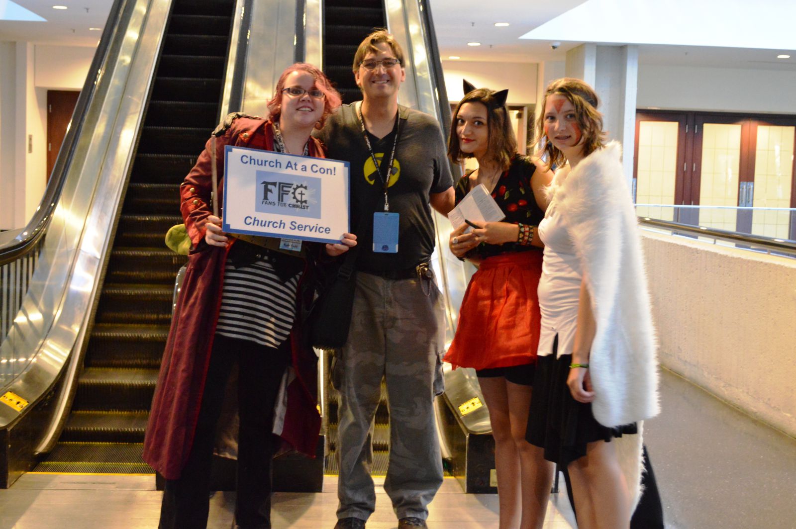 The author (cosplaying Captain Hammer...badly) and his 2 daughters, Claire (cosplaying herself+cat ears) and Ruth (cosplaying Princess Mononoke) posing with a Fans for Christ church greeter.